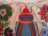 Coussin brode main avec des motifs insectes et fleur, commerce equitable.